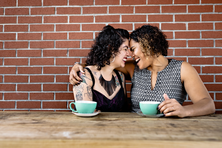 An engaged lesbian couple have coffee in Brooklyn outside of Stonefruit Espresso.